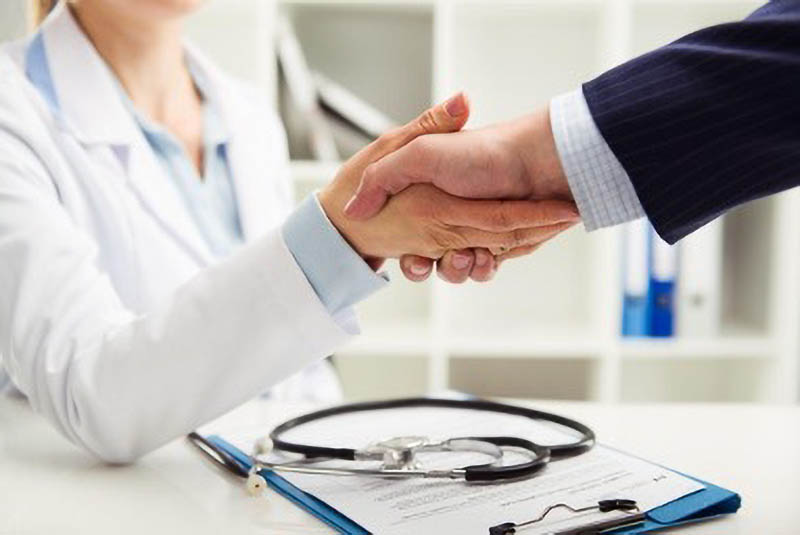 Doctor and nonprofit executive shaking hands.